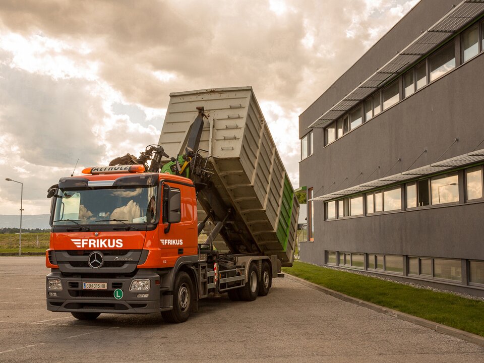 Lkw stellt Container vor Haus ab.