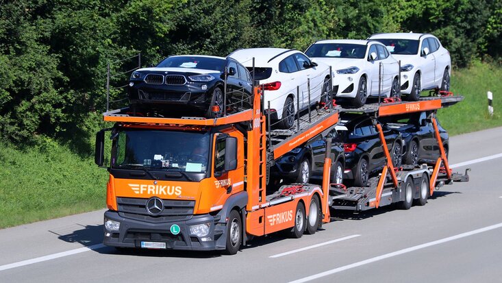 Autotransporter beladen fährt auf Landstraße - FRIKUS