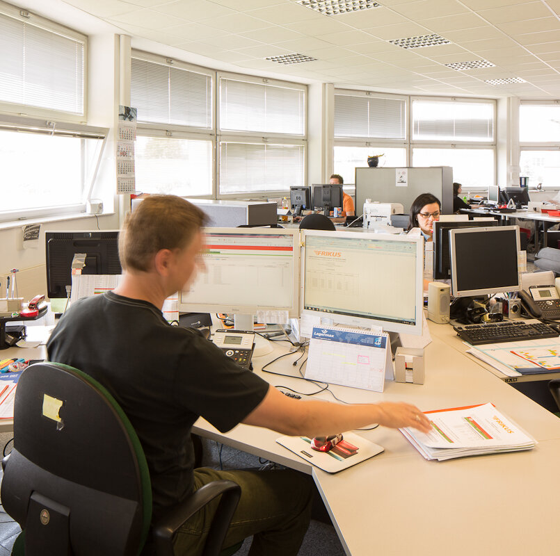 Mann sitzt im Büro vor Bildschirm.