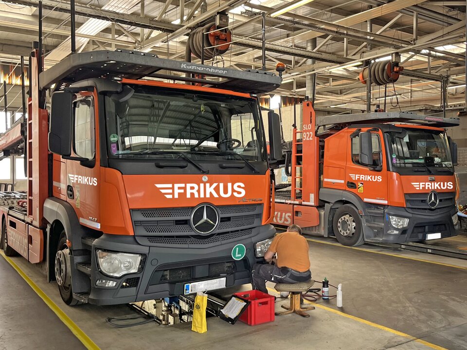 Mann repariert Lkw Scheinwerfer in Werkstatt