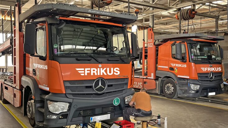 Mann repariert Lkw Scheinwerfer in Werkstatt