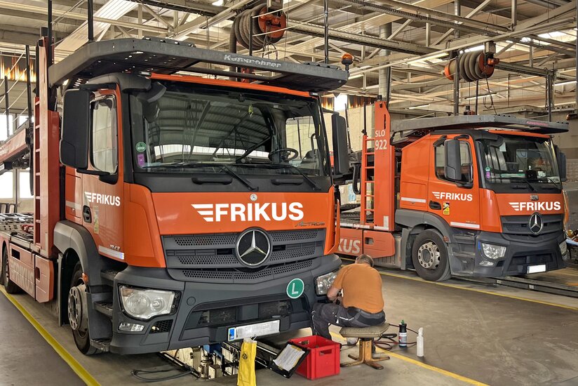 Mann repariert Lkw Scheinwerfer in Werkstatt
