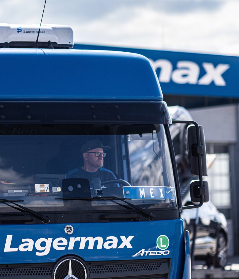 Man sieht einen Lagermax LKW mit einem Fahrer im Hochformat