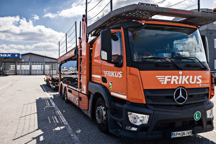 Man sieht einen orangen Frikus Transporter LKW im Querformat